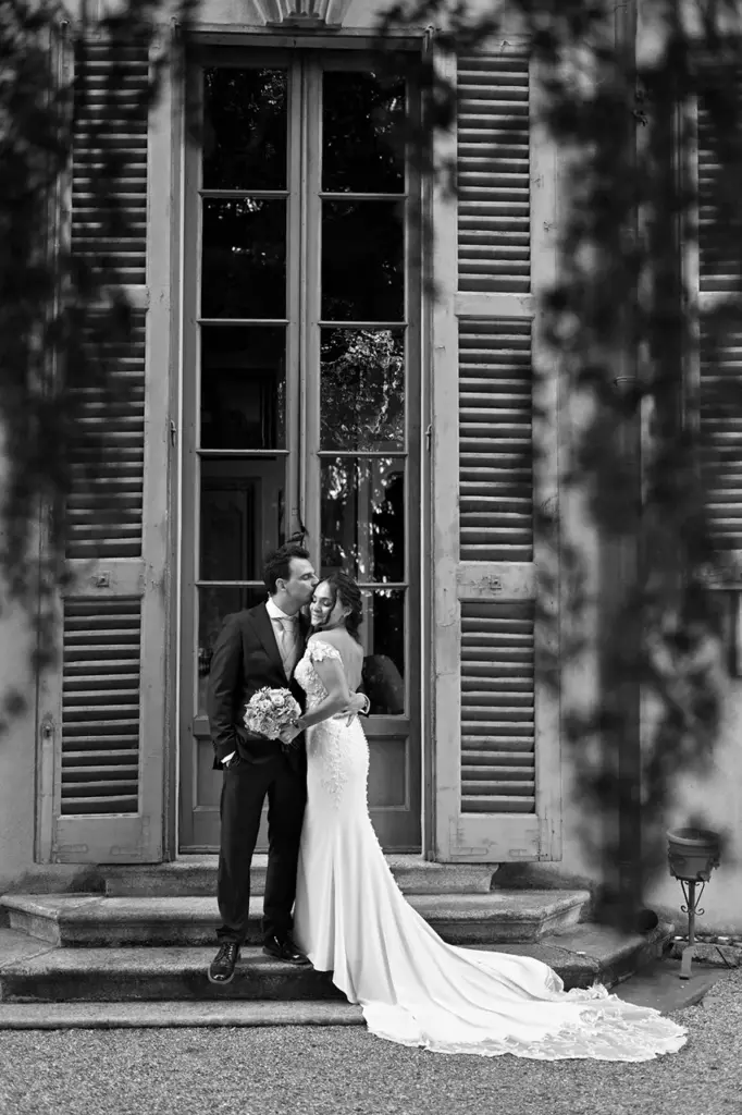 Sposi davanti all'ingresso di una villa storica durante il servizio fotografico di matrimonio in bianco e nero.