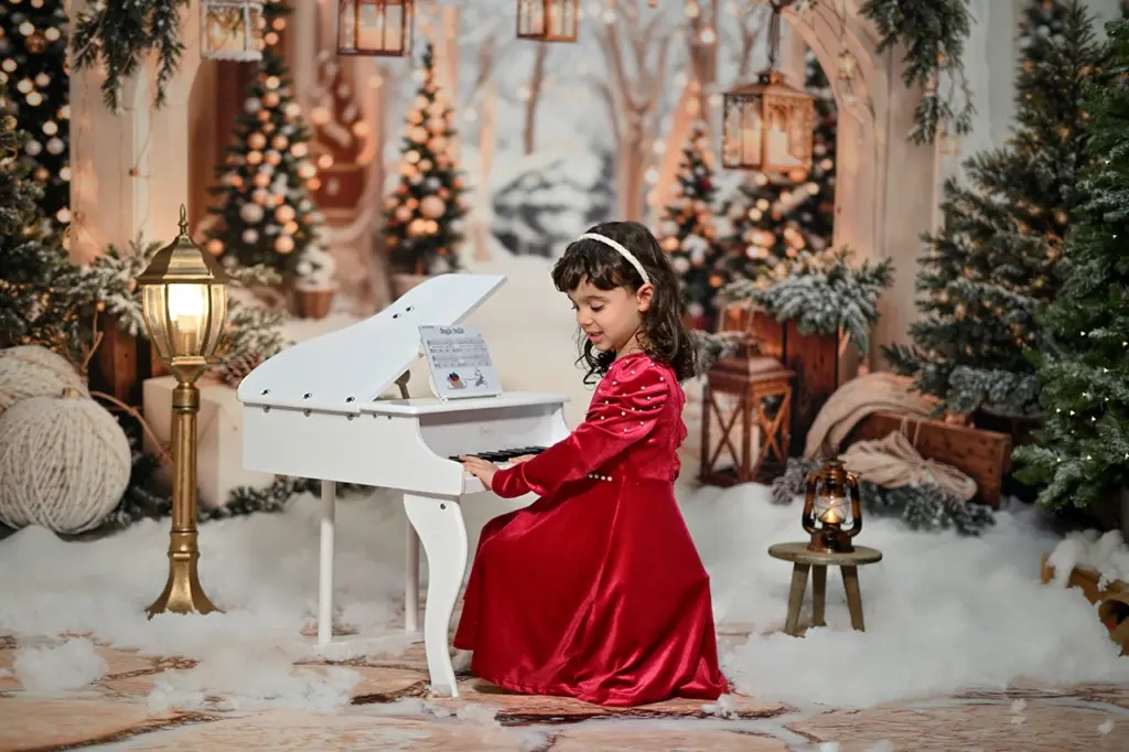Bambina accanto al pianoforte nella scenografia fotografica di Natale