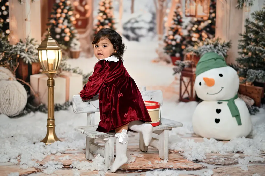 Bambina con abito rosso durante un servizio fotografico di Natale a Torino