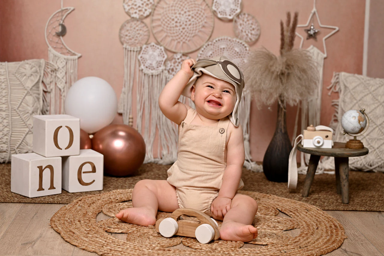 Bambino nella scenografia boho con cubi ONE per il primo compleanno