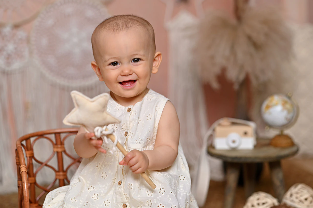 Bambina sorridente durante il servizio fotografico del suo primo compleanno