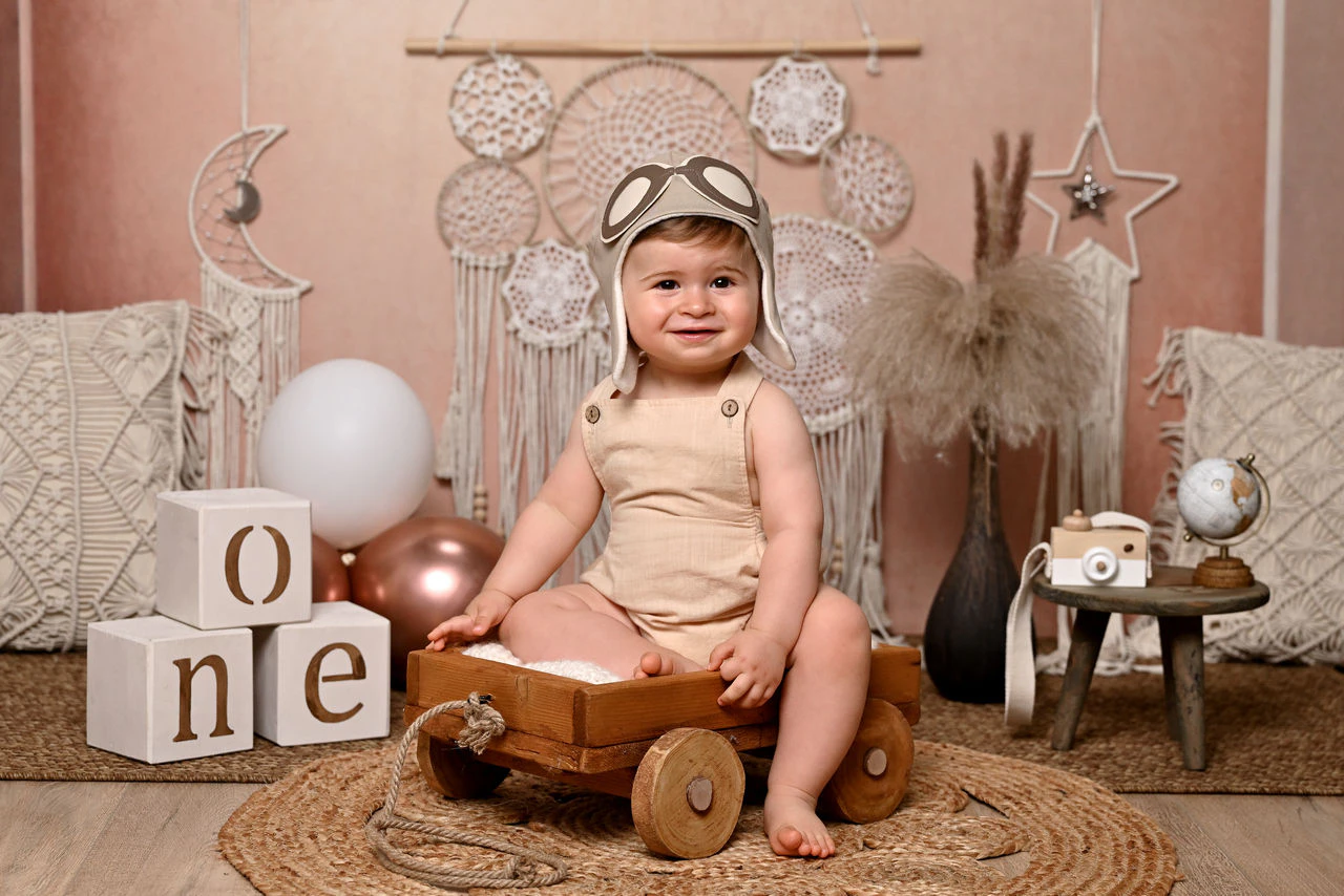 Bambino seduto nella scenografia boho con decorazioni ONE