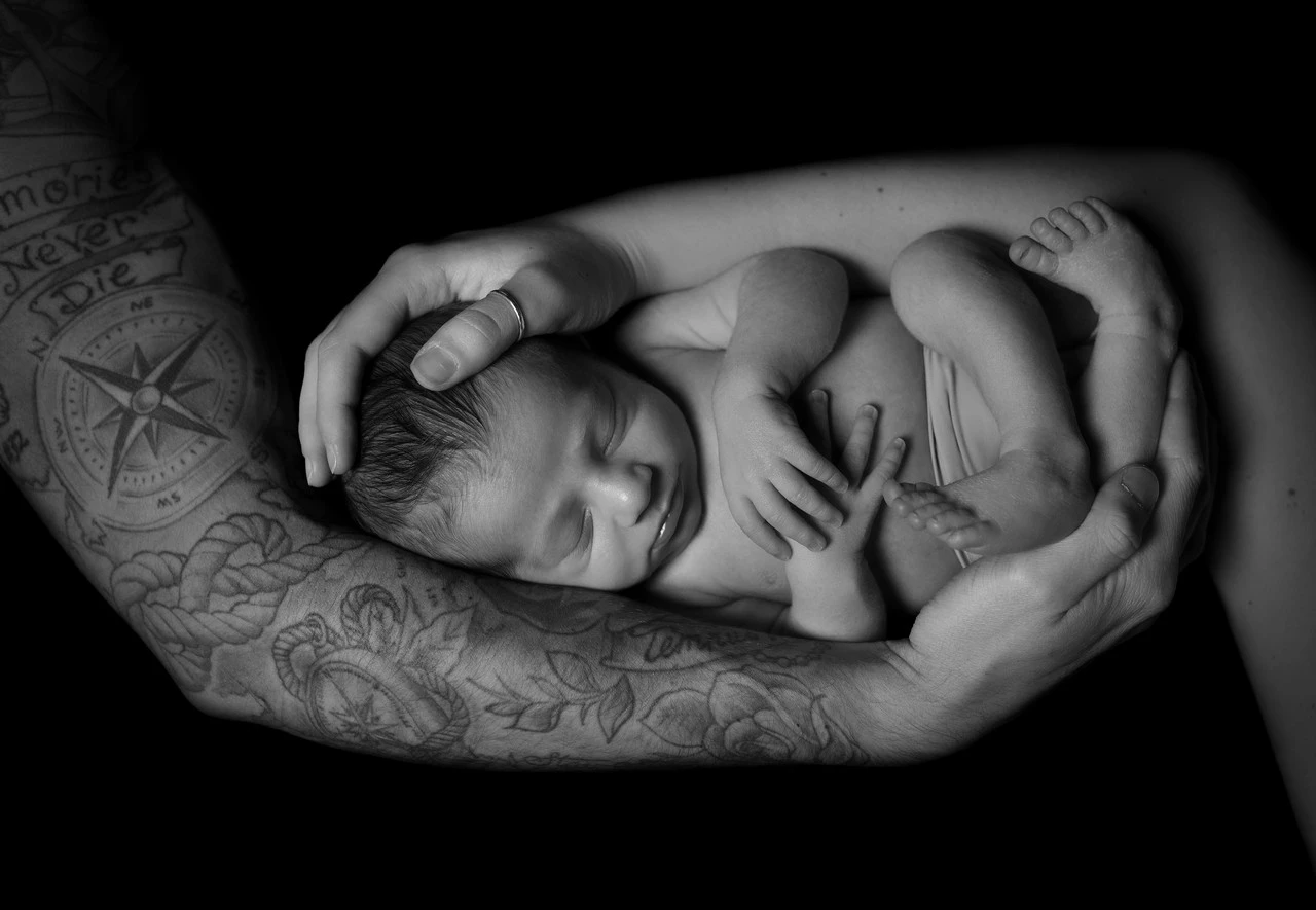 Neonato addormentato fotografato in bianco e nero