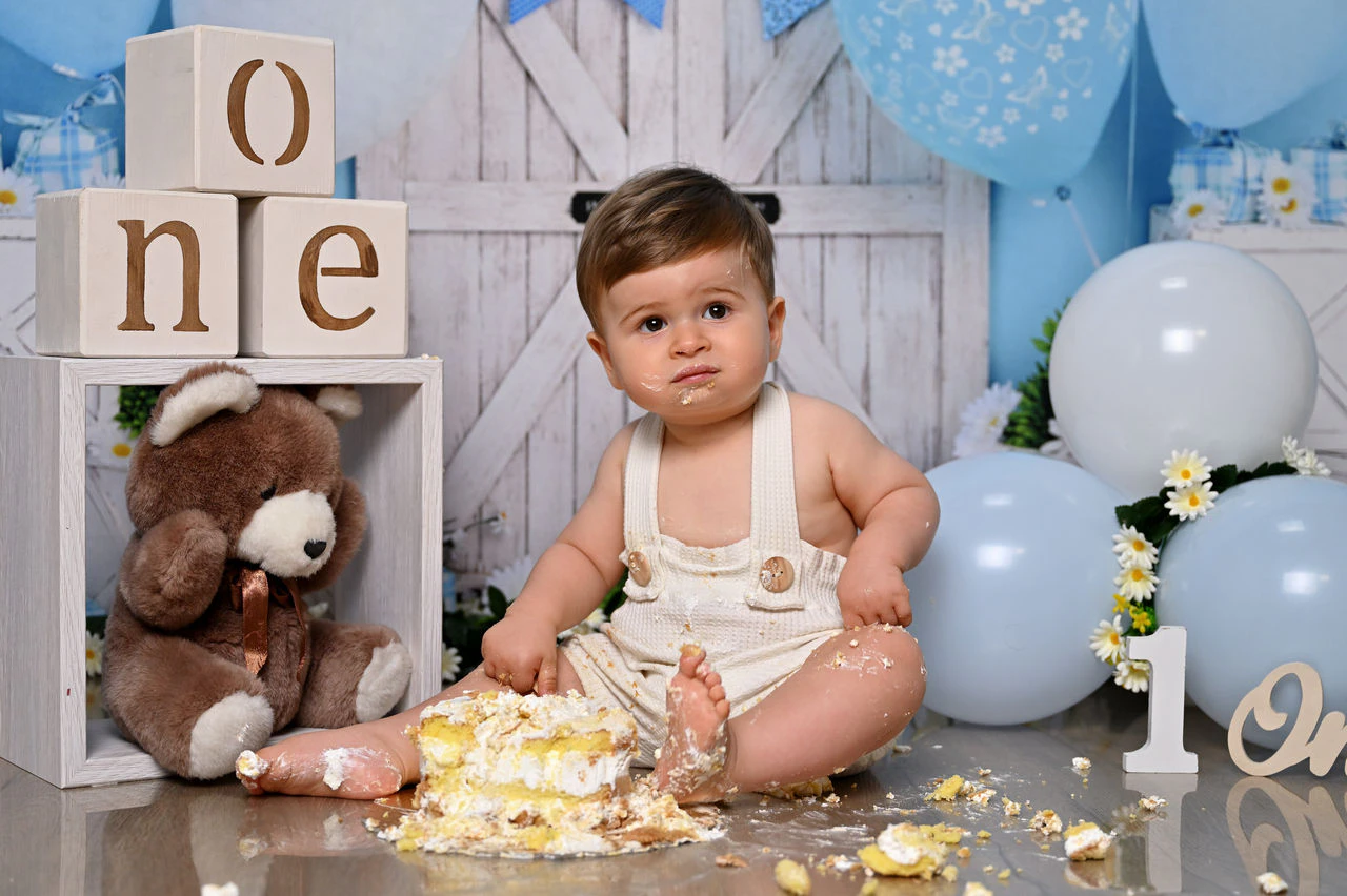 Bambino con torta nella scenografia azzurra durante il servizio Smash Cake