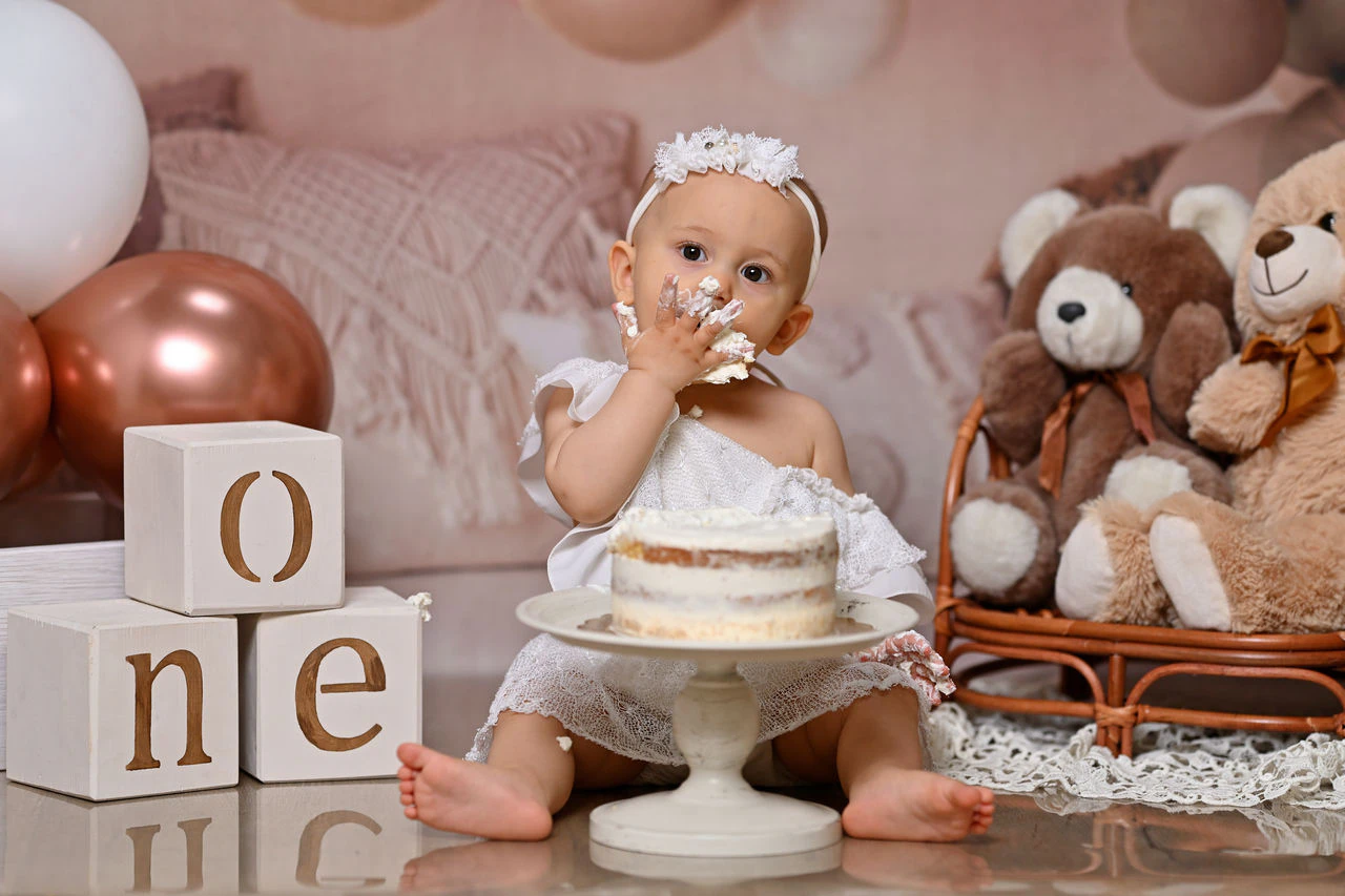 Bambina davanti alla torta con orsacchiotti durante il servizio Smash Cake