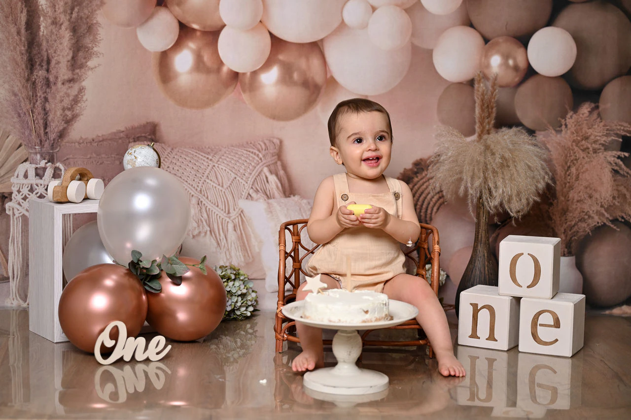Bambino davanti alla torta circondata da palloncini durante il servizio Smash Cake