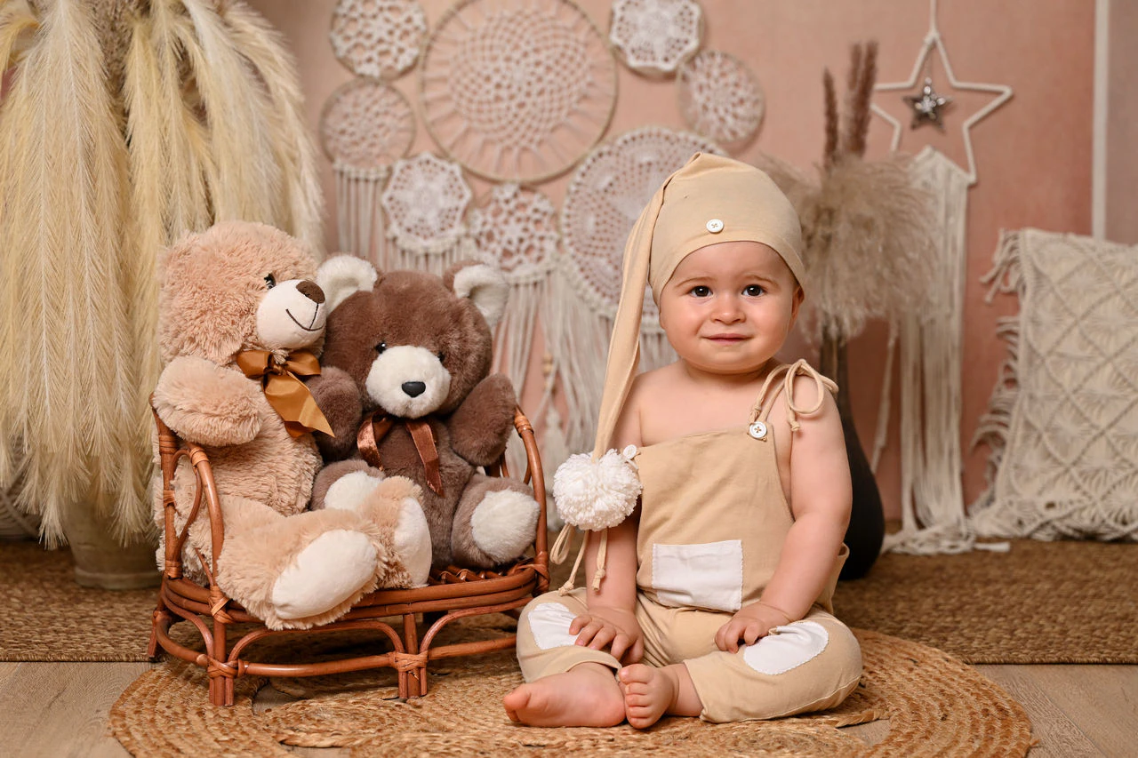 Bambino con orsacchiotti nella scenografia boho del primo compleanno