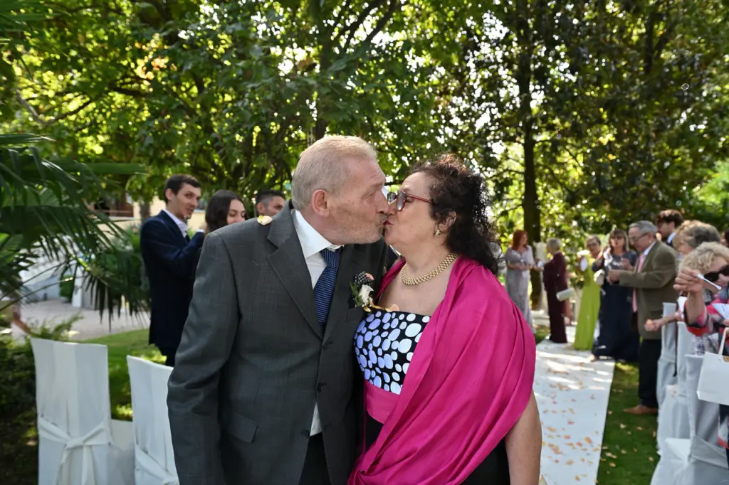Salvatore e Maria si scambiano un bacio nel giardino dopo la cerimonia del loro cinquantesimo anniversario.